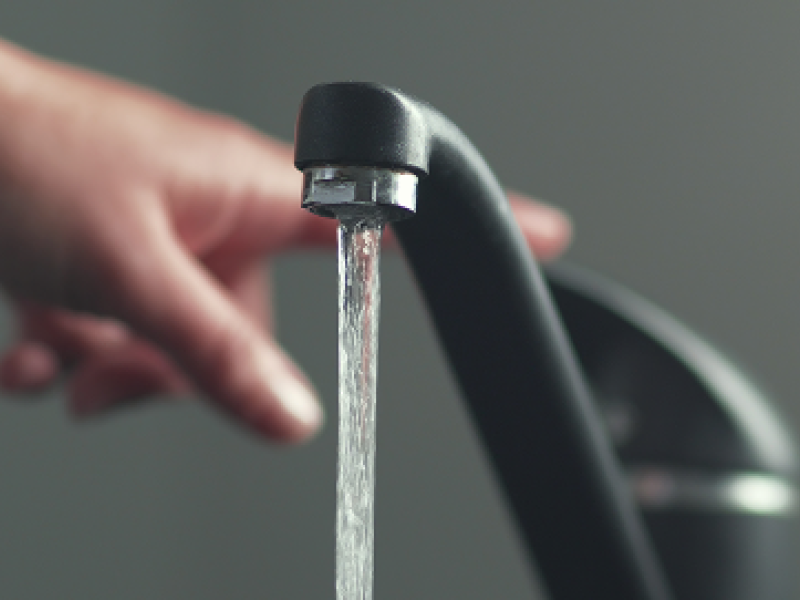 Aufgedrehter schwarzer Wasserhahn