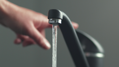 Aufgedrehter schwarzer Wasserhahn