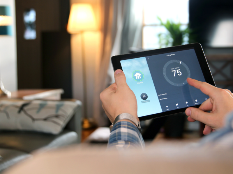 Person nimmt auf einem Tablet Einstellungen für das Smart Home vor
