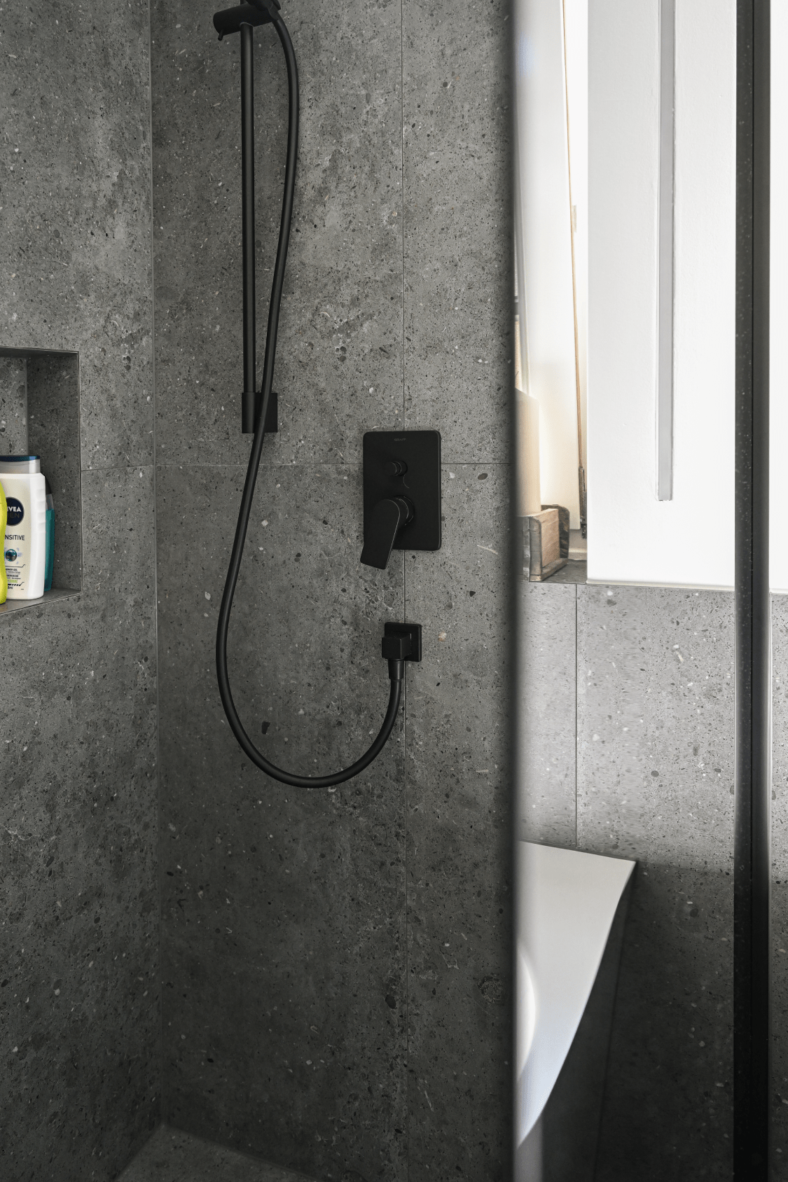 Schwarze Duscharmatur auch grauer Fließe